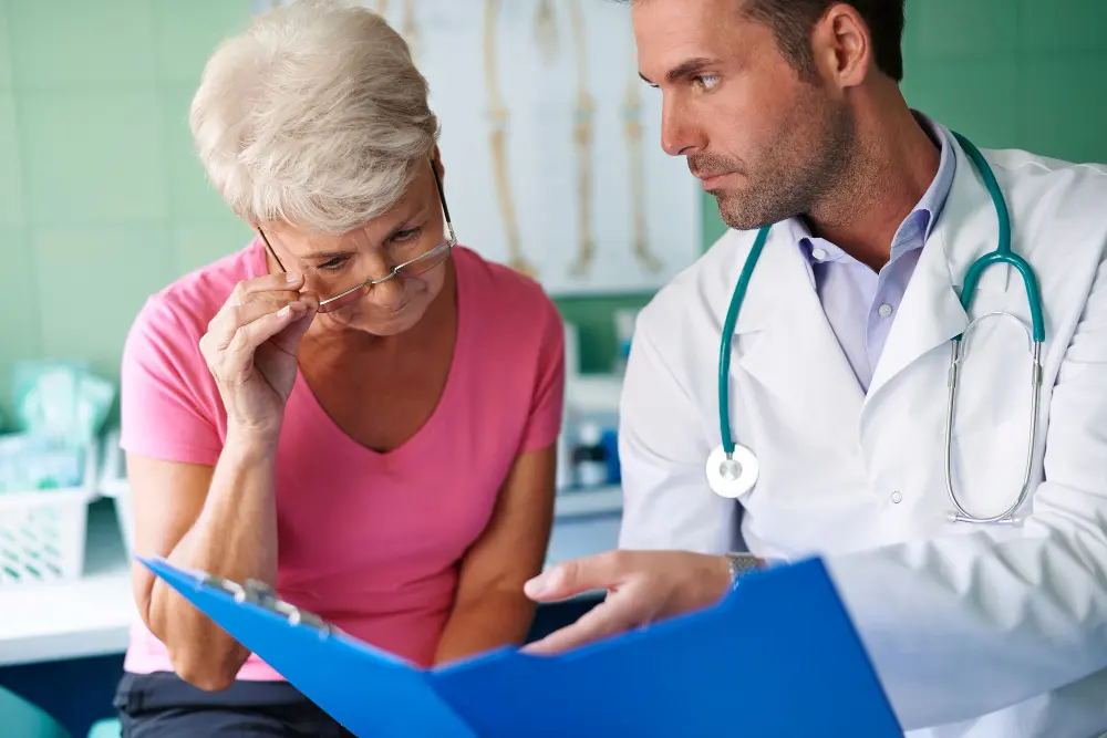 Médico conversando com uma paciente enquanto analisam documentos.