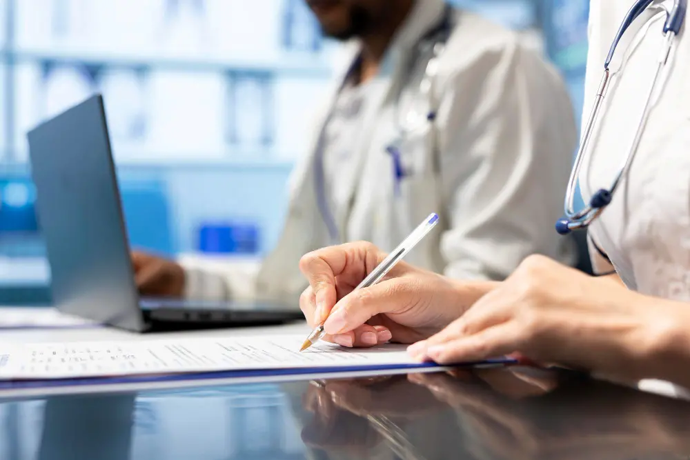 Profissionais de saúde analisando documentos em um ambiente hospitalar.